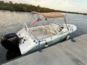 A well-maintained center console boat docked peacefully, showcasing its sleek design and American flag, perfect for a day on the water.