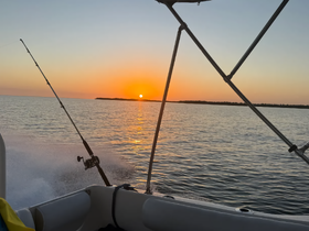 A serene sunset view from a fishing boat, capturing the beauty of the horizon as the day ends — perfect for fishing enthusiasts and sunset lovers.