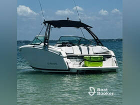 A sleek speedboat anchored in shallow waters, showcasing its stylish design and spacious seating — perfect for a day on the water.