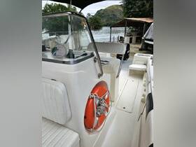 An interior view of a boat's helm and seating area, showcasing the clean design and safety features, perfect for a day on the water.