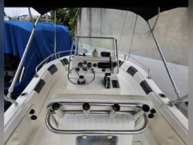 An interior view of a boat's helm and seating area, showcasing the console and steering wheel, ideal for navigating the waters.