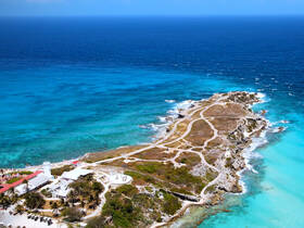 A stunning aerial view of a picturesque island surrounded by vibrant turquoise waters, showcasing the natural beauty and coastline perfect for exploration and relaxation.