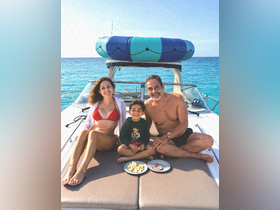 A joyful family enjoys snacks on the deck of a boat, creating memorable moments under the sun — perfect for family outings and adventures on the water.