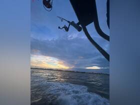 A serene sunset view from a fishing boat, showcasing fishing gear against a backdrop of tranquil waters — perfect for evening fishing adventures.
