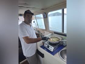 A chef prepares a delicious meal on board, showcasing the culinary experience available during your boating adventure.