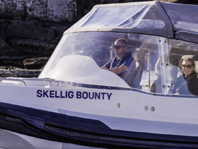 A couple enjoys a scenic ride aboard the Skellig Bounty, showcasing the thrill of boating adventures.