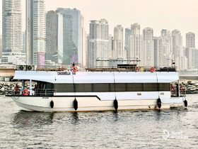The Cinderella yacht glides through the water with a stunning city skyline in the background, showcasing a perfect blend of luxury and urban scenery.