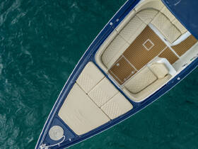An aerial view of the luxurious interior seating of a boat, showcasing plush cushions and a stylish layout, perfect for relaxation on the water.