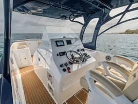 A sleek view of the helm area inside a boat, showcasing modern controls and comfortable seating, perfect for navigating the open waters.
