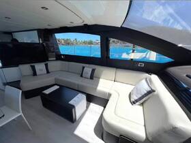 A stylish interior view of a boat's lounge area featuring comfortable seating and large windows showcasing beautiful turquoise waters outside.