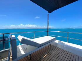A serene view from the lounge area of a yacht, showcasing comfortable seating and stunning turquoise waters — perfect for relaxation and enjoying the scenery.
