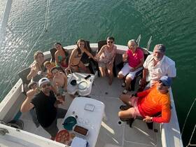 A joyful family gathering on a boat, enjoying drinks and food together — a perfect setting for memorable celebrations on the water.