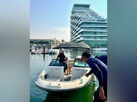 A group of people prepares to board a Sea Ray boat at a marina, showcasing a vibrant boating experience in a modern waterfront setting.