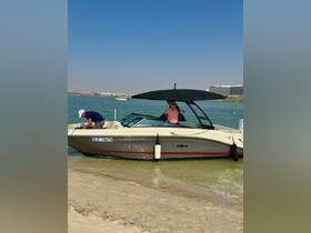 Two individuals enjoy a sunny day on a boat at the beach, showcasing a perfect blend of relaxation and fun on the water.