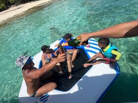 A joyful group toasts with champagne on a floating mat in crystal-clear waters, creating unforgettable memories under the sun.