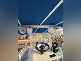 A detailed view of the helm and console inside a boat, showcasing modern navigation equipment and comfortable seating, perfect for a day on the water.