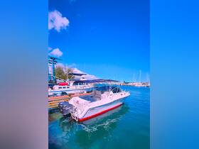 A sleek yacht docked in clear waters, showcasing its elegant design against a vibrant blue sky — perfect for luxury boating experiences.