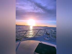 A stunning sunset view from the bow of a boat, showcasing the tranquil waters and vibrant sky — perfect for evening cruises.