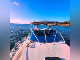 Two individuals enjoy a scenic boat ride, showcasing the thrill of cruising on open waters under a clear blue sky.