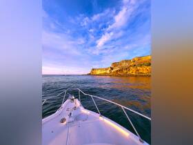A stunning view from the bow of a boat, showcasing the rocky coastline and vibrant sky, perfect for capturing the essence of a scenic boating adventure.