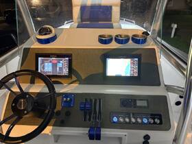A detailed view of the helm and console area of a boat, showcasing modern navigation screens and controls, perfect for boating enthusiasts and those interested in marine technology.