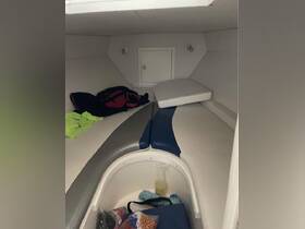 Interior view of a boat cabin featuring seating and storage, ideal for relaxing and stowing gear while on the water.