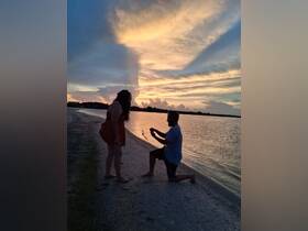 A romantic sunset proposal on the beach captures a couple in a heartfelt moment, perfect for memorable engagements and love stories.