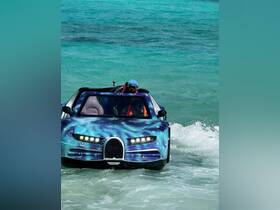 A unique speedboat with a striking design navigates through turquoise waters, showcasing an exciting on-water experience.