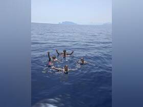 A lively group enjoys a refreshing swim in the open ocean, capturing the essence of summer fun and adventure on the water.