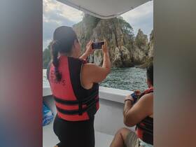 A guest captures the stunning rock formations during a boat tour, showcasing the beauty of the surrounding scenery and the excitement of exploring nature.