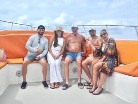 A cheerful group enjoys drinks and laughter aboard a boat, perfect for a fun day on the water with friends.