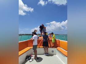 A lively group enjoys a fun day on the boat, capturing moments of joy and celebration under the sun — perfect for family outings or group adventures.