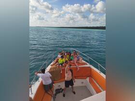 A lively group of friends and family enjoy a fun day on the water, taking a selfie aboard their boat — perfect for capturing memorable moments on a sunny adventure.