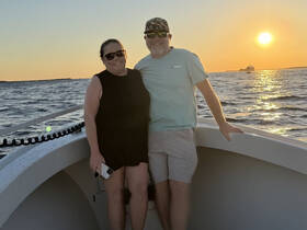 A couple enjoys a romantic sunset on a boat, capturing a perfect moment of celebration on the water.