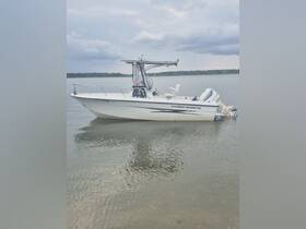 A sleek Hydra-Sports boat docked in calm waters, showcasing its design and structure against a cloudy sky.