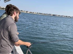 Two friends enjoy a fishing trip on the water, showcasing the excitement of on-water activities and camaraderie.