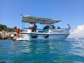 A lively group enjoys a fun day on the water, with one person climbing aboard while others relax on the boat — perfect for summer excursions and aquatic adventures.