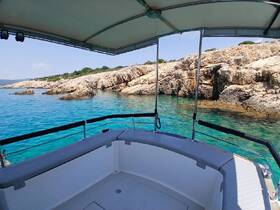 A serene view from the deck of a boat, showcasing clear turquoise waters and rocky coastal scenery — perfect for exploring hidden coves and enjoying nature.
