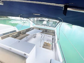 A spacious and stylish interior lounge area of a yacht, featuring comfortable seating and a table, perfect for relaxing while enjoying the views of the marina.