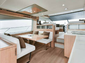 A modern and spacious interior of a boat featuring a cozy dining area and comfortable seating, perfect for relaxing and enjoying meals while at sea.