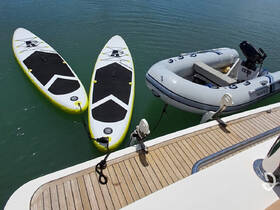 Two paddleboards and an inflatable boat are neatly arranged at the dock, showcasing the perfect setup for water activities and adventures.