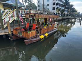 A vibrant tiki boat docked at the pier, showcasing its unique design and inviting atmosphere, perfect for fun outings on the water.