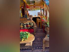 A vibrant and cozy interior of a boat featuring comfortable seating and tropical decor, perfect for relaxing while enjoying scenic views on the water.