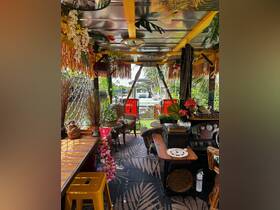 A beautifully decorated interior of a boat featuring tropical decor, comfortable seating, and a cozy lounge area, perfect for relaxing on the water.
