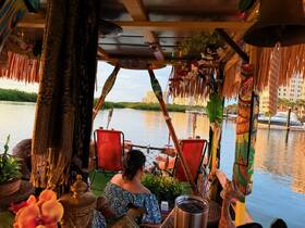 A cozy interior view of a tiki boat featuring vibrant decor and comfortable seating, perfect for relaxing on the water.