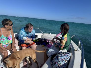A fun day on the water with friends and a dog, as they prepare for snorkeling adventures aboard a boat — perfect for family outings and aquatic exploration.