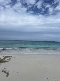 A scenic view of a beach with gentle waves and a cloudy sky, capturing the tranquil essence of coastal landscapes.