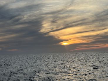 A stunning sunset over the ocean, showcasing vibrant colors and serene waters — perfect for capturing the beauty of nature during a boating adventure.