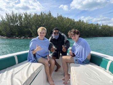 A group of friends enjoying a day on the water, giving thumbs up while relaxing on a boat — perfect for memorable adventures and fun outings.