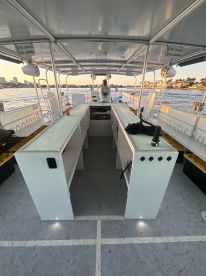 Interior view of a boat's helm area, showcasing the seating and console setup, perfect for navigating the waters while enjoying the scenery.